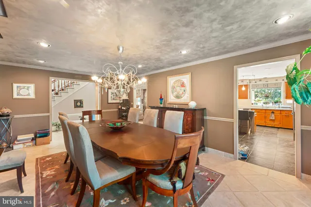 a dining room with furniture a chandelier and wooden floor