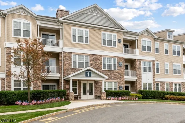 a front view of a residential apartment building with a yard