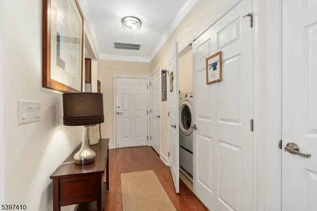 a hallway with white walls and wooden floor