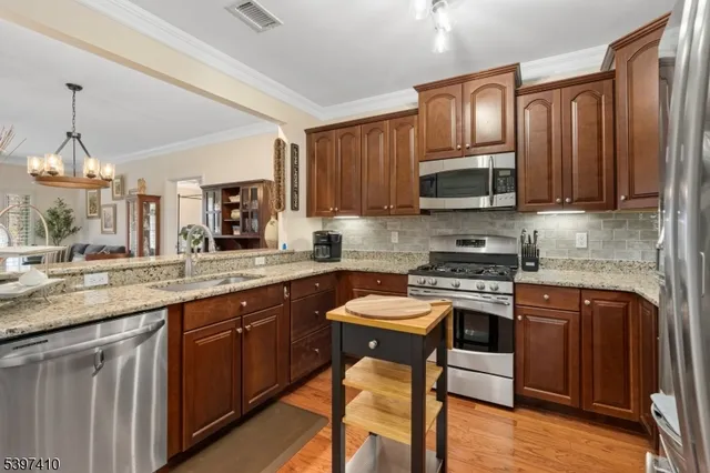 a kitchen with stainless steel appliances granite countertop a stove top oven a sink dishwasher and a microwave oven on the blue kitchen countertops