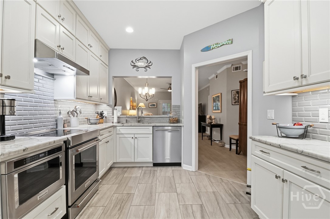 18 River Walk, Unit 18 Savannah, GA 31410 - Photo 5 of 27 Quartz counters, tile backsplash, KitchenAid Stainless appliances, including microwave drawer.