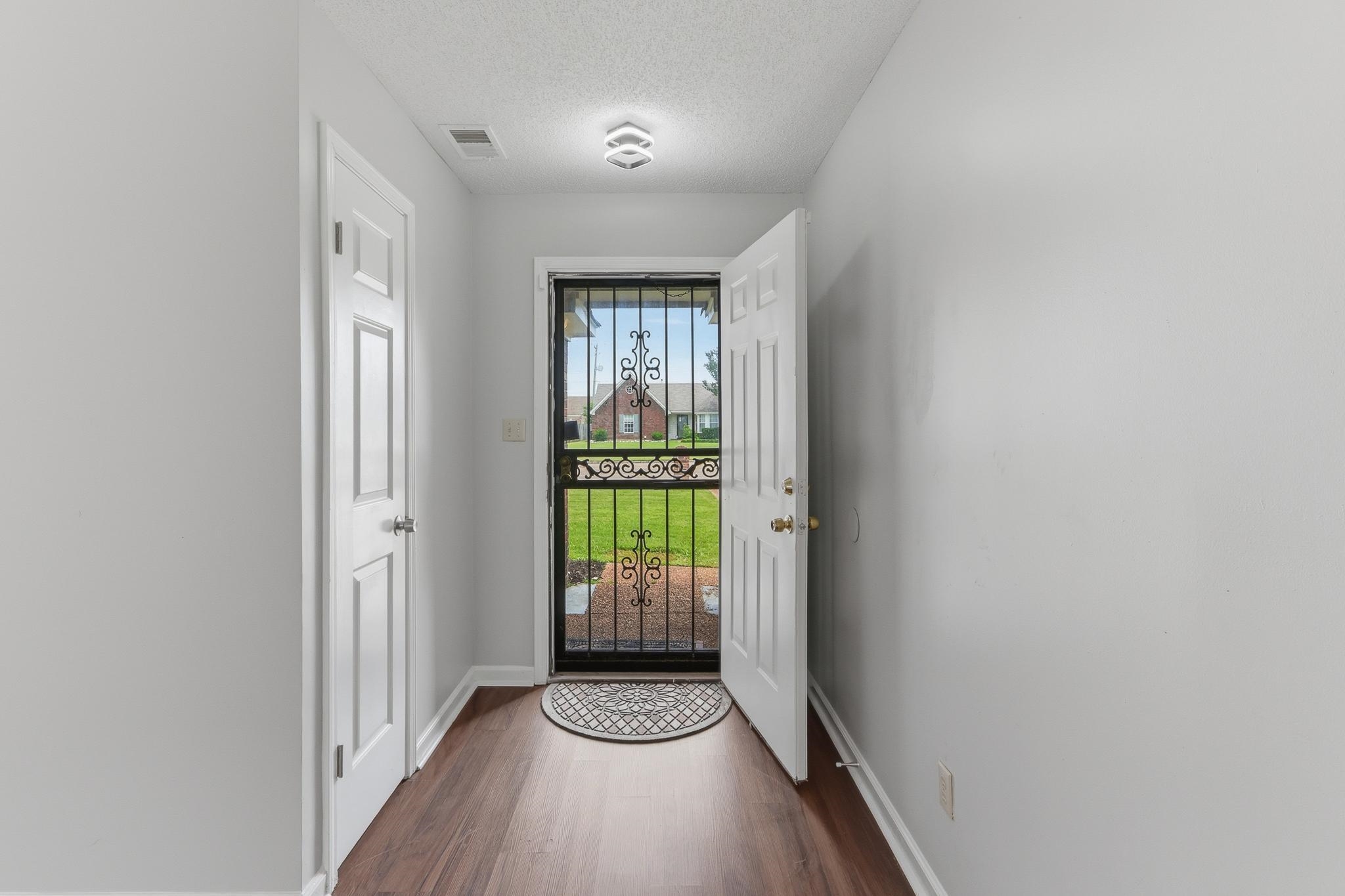 4101 Long Creek Road Memphis, TN 38125 - Photo 27 of 36 Entryway featuring wood-finish flooring, white trim, and a contemporary ceiling light fixture