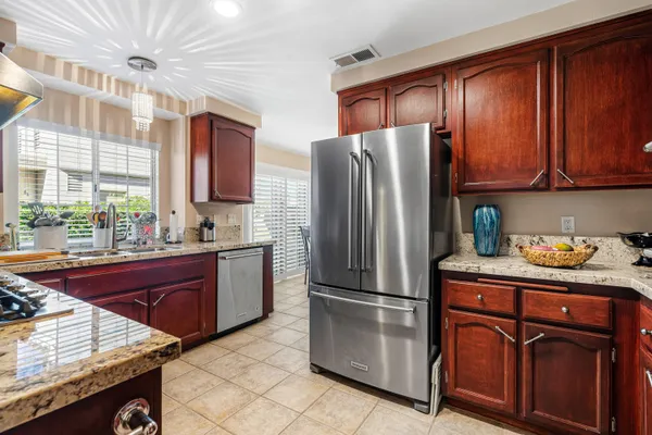 a kitchen with a sink a stove cabinets and wooden floor