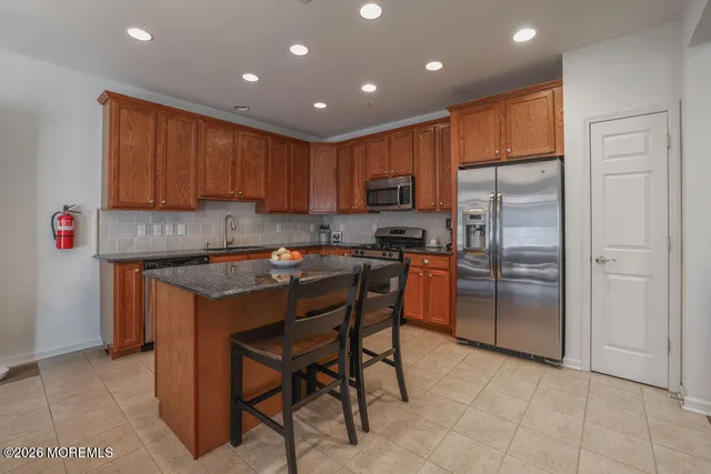 a kitchen with stainless steel appliances granite countertop a refrigerator a stove a sink and a refrigerator