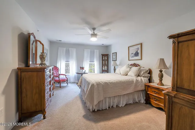 a spacious bedroom with a bed and a flat screen tv