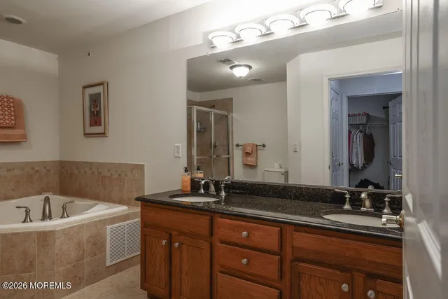 a bathroom with a granite countertop bathtub sink and mirror