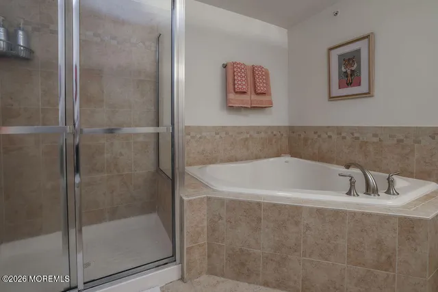 a white bath tub sitting next to a shower