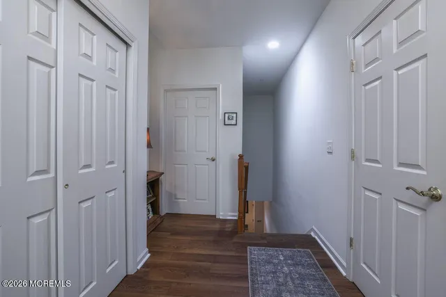 a view of a hallway with wooden floor and closet area