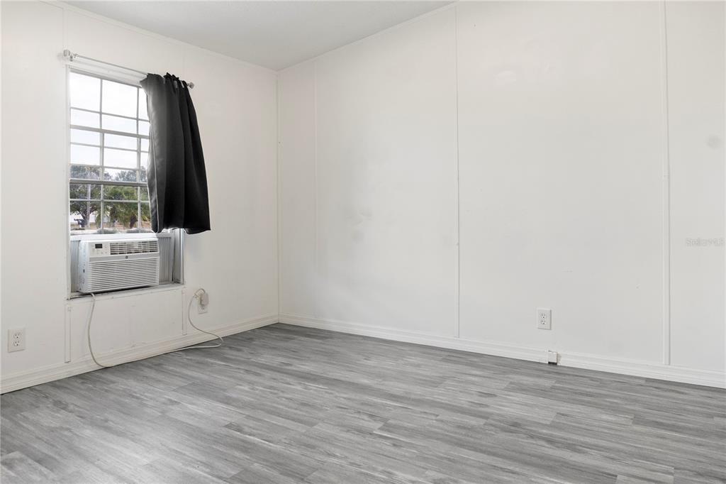 6526 Jack Street Punta Gorda, FL 33982 - Photo 13 of 19 an empty room with wooden floor and windows