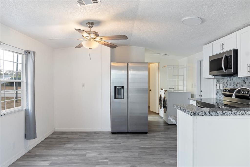 6526 Jack Street Punta Gorda, FL 33982 - Photo 6 of 19 a kitchen with stainless steel appliances granite countertop a refrigerator a stove a sink and a microwave