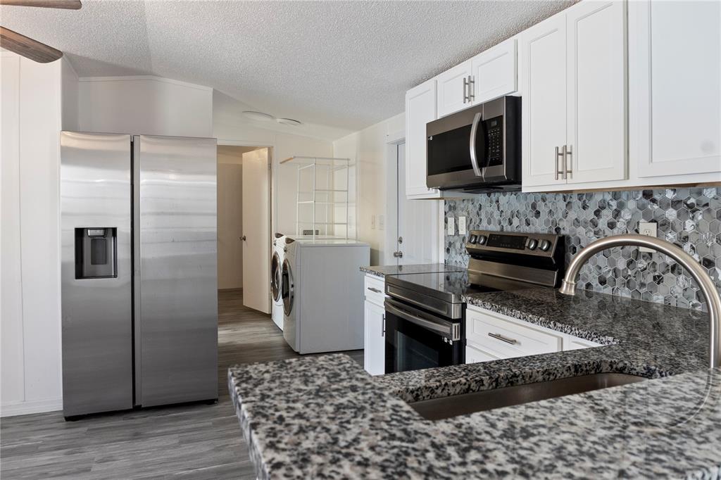 6526 Jack Street Punta Gorda, FL 33982 - Photo 10 of 19 a kitchen with stainless steel appliances granite countertop a refrigerator a stove top oven a sink and dishwasher