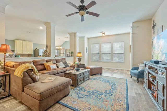 a living room with furniture ceiling fan and a rug