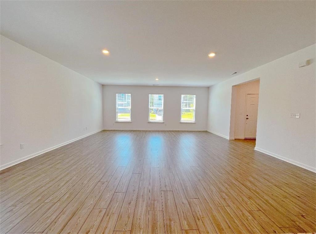 117 Goshawk Street Braselton, GA 30517 - Photo 5 of 28 a view of empty room with window and wooden floor