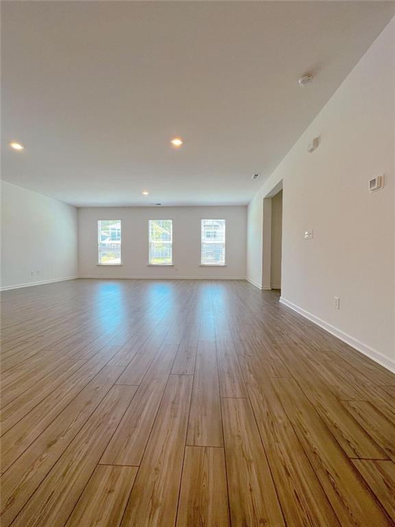 117 Goshawk Street Braselton, GA 30517 - Photo 6 of 28 a view of empty room with window and wooden floor