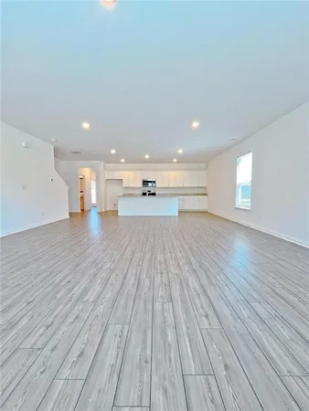 a big room with wooden floor and windows