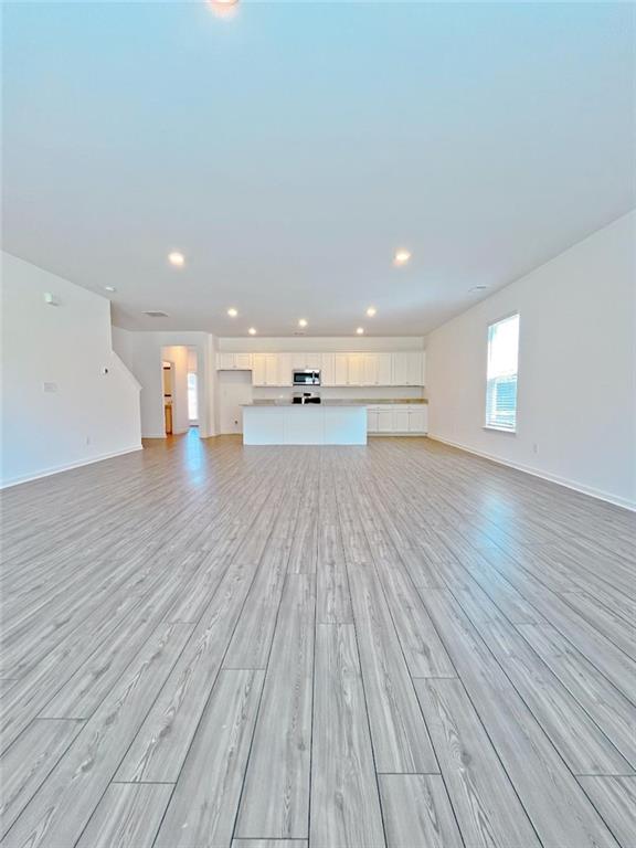 117 Goshawk Street Braselton, GA 30517 - Photo 7 of 28 a big room with wooden floor and windows