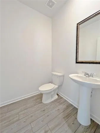 a bathroom with a toilet a sink and mirror