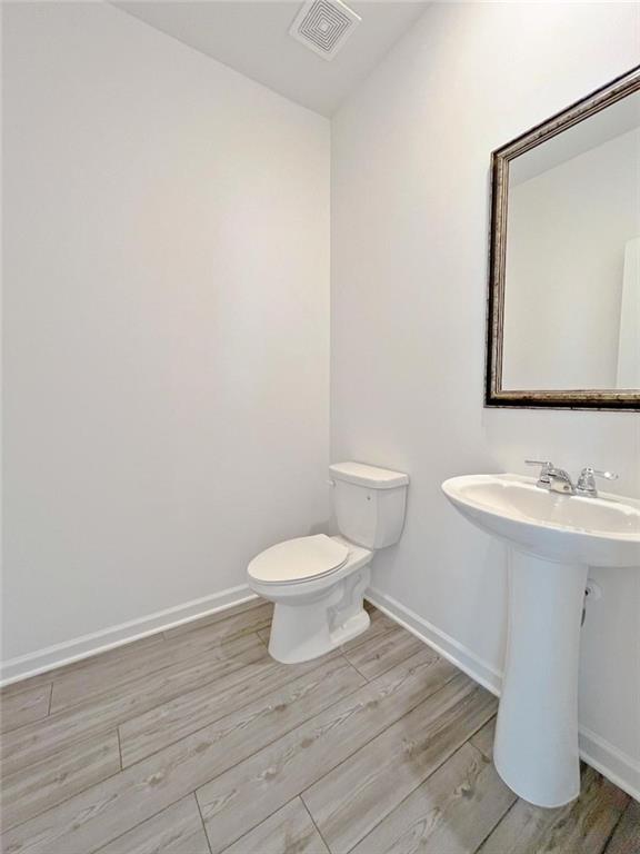 117 Goshawk Street Braselton, GA 30517 - Photo 10 of 28 a bathroom with a toilet a sink and mirror