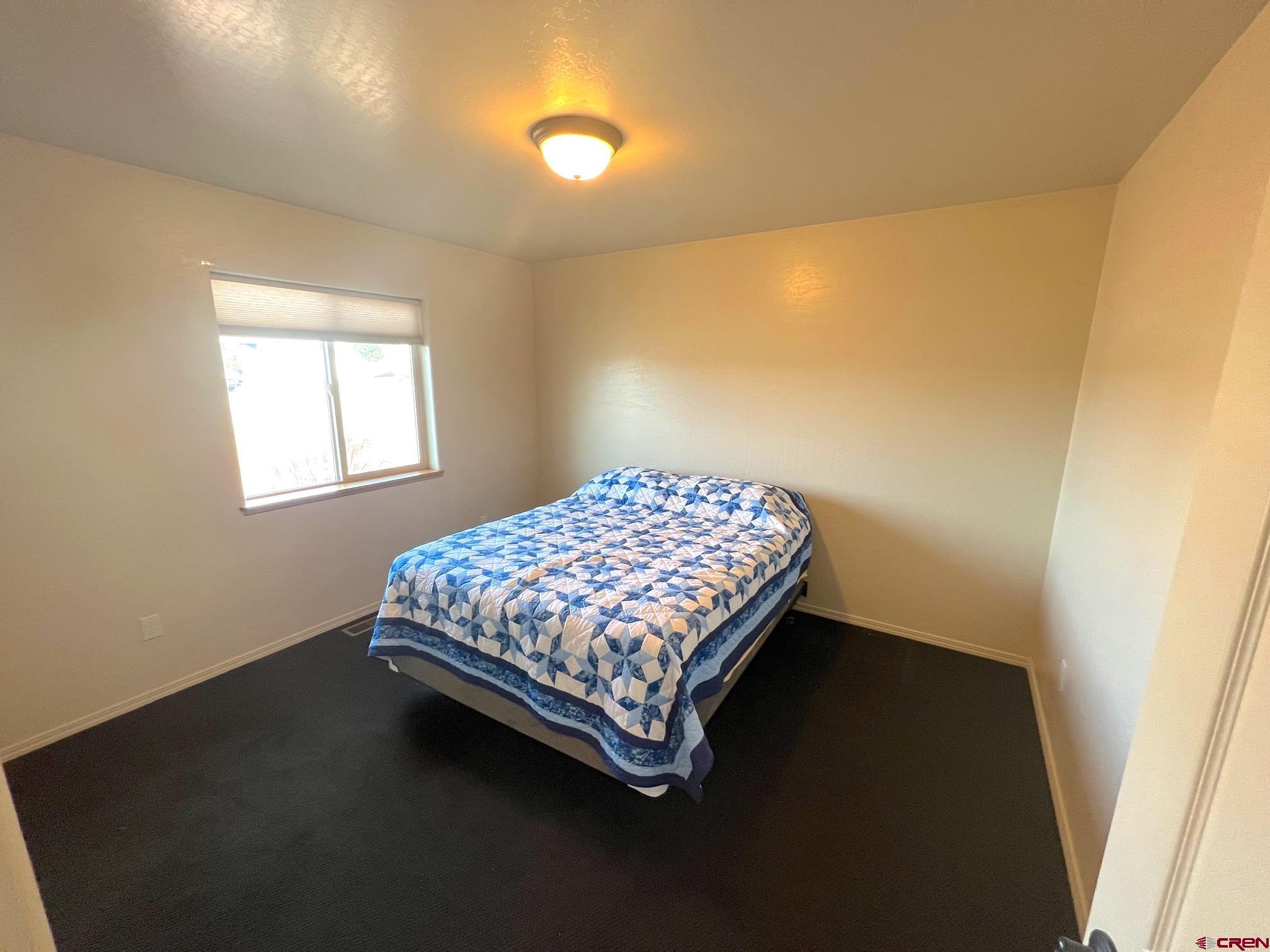 930 Bluffs Boulevard Cortez, CO 81321 - Photo 18 of 28 a bedroom with a bed and a window