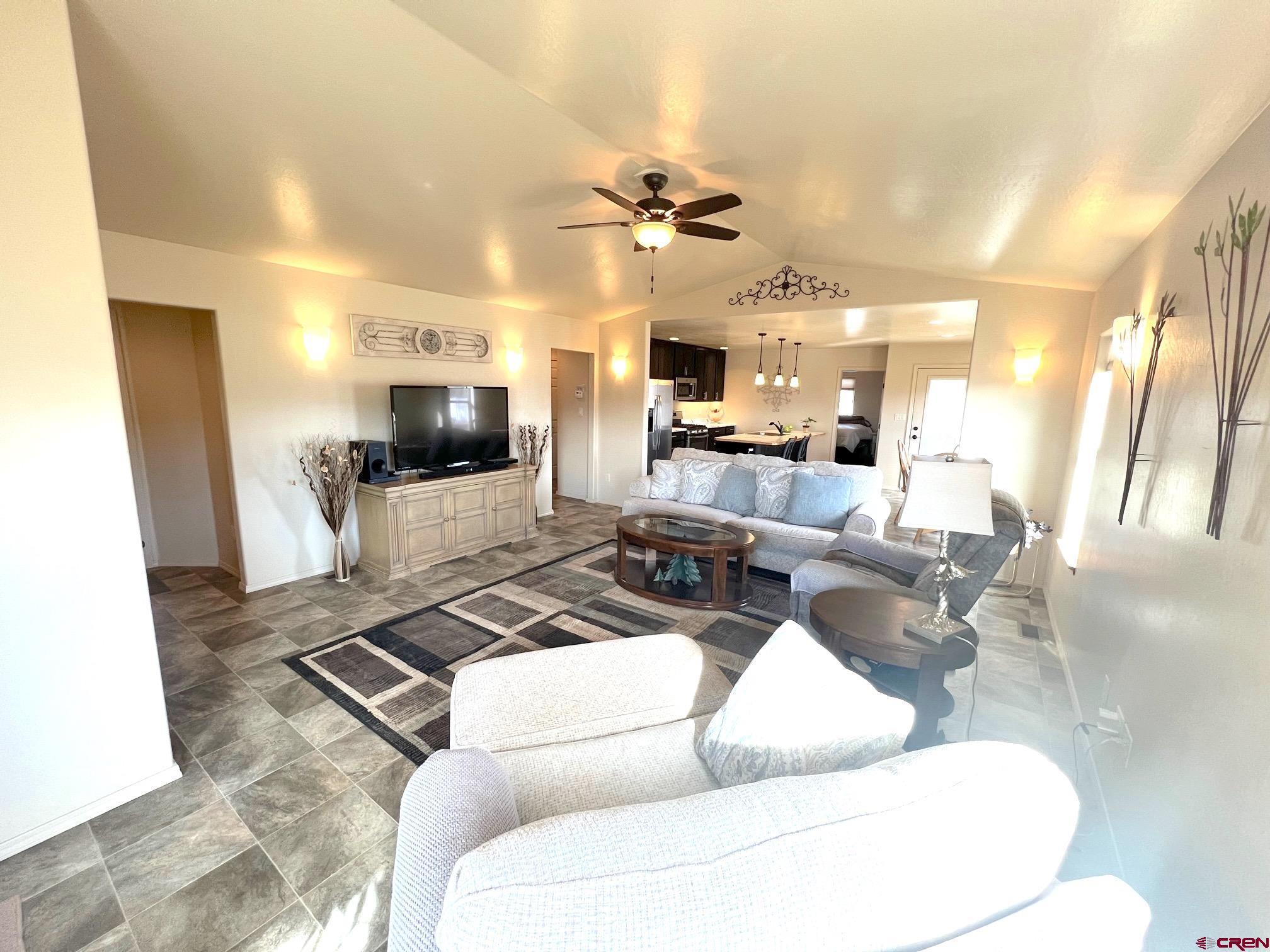 930 Bluffs Boulevard Cortez, CO 81321 - Photo 3 of 28 a living room with patio furniture and a flat screen tv