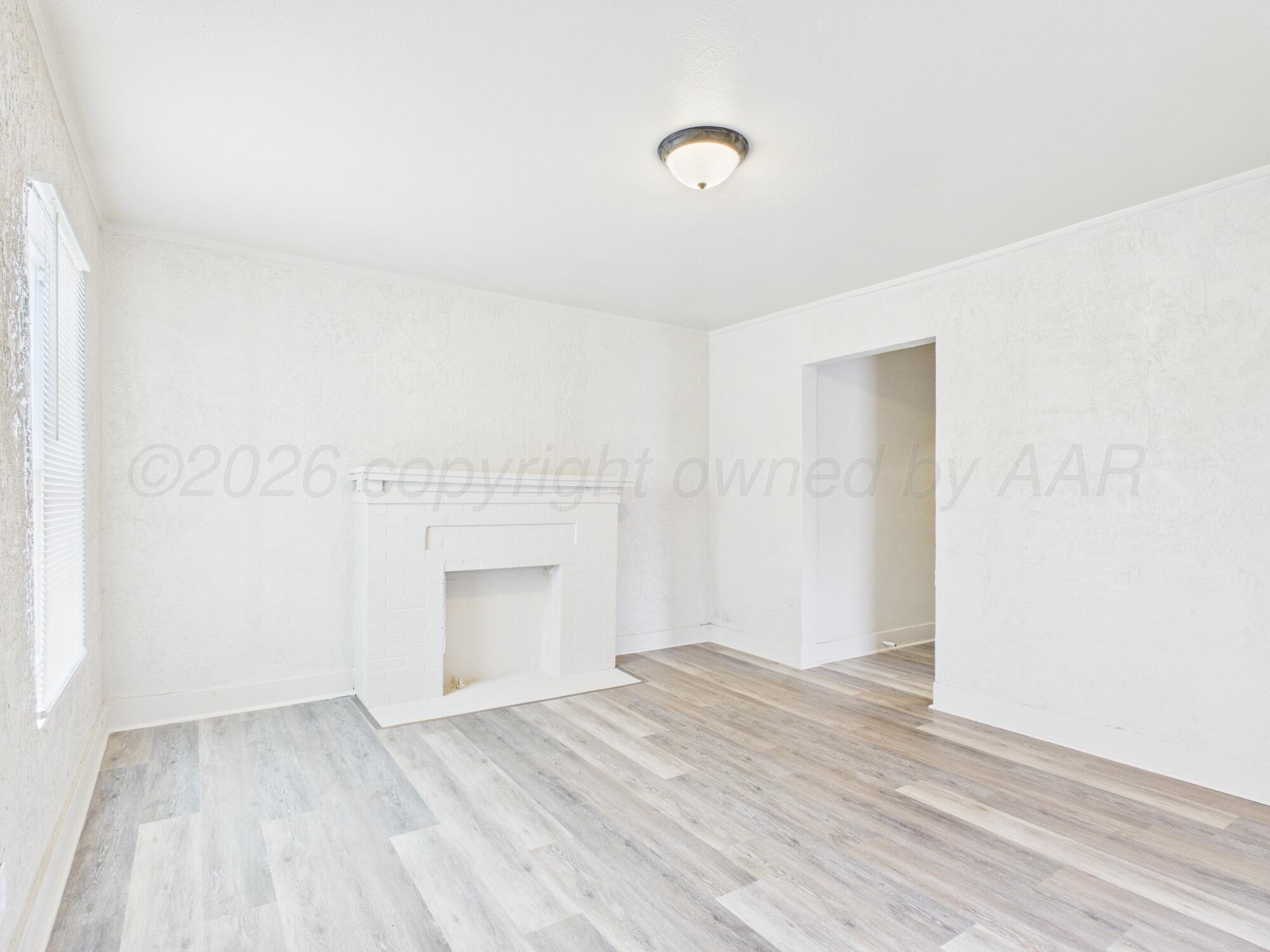 1111 Southwest 13th Avenue Amarillo, TX 79102 - Photo 11 of 20 a view of empty room with wooden floor and fireplace