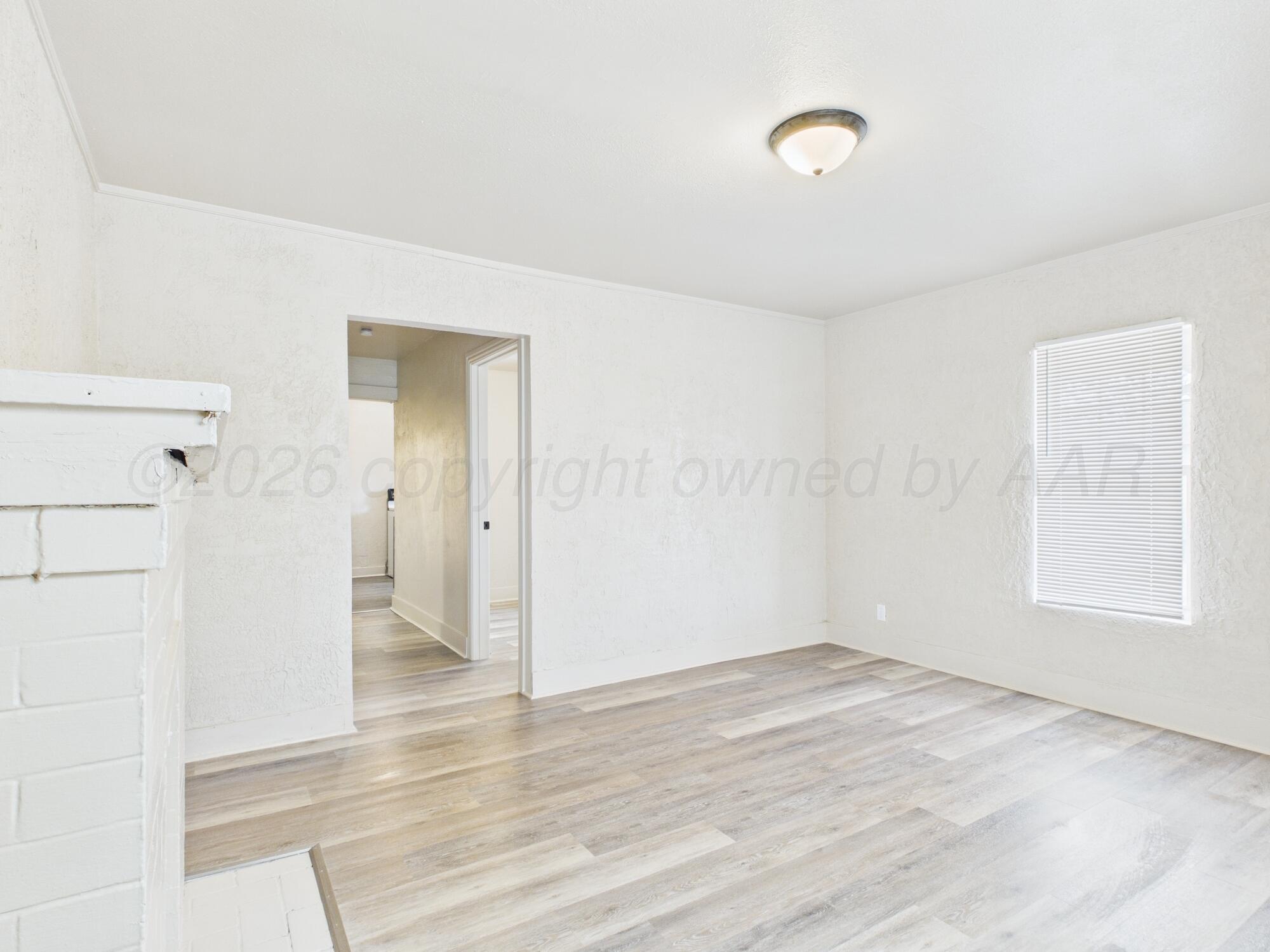 1111 Southwest 13th Avenue Amarillo, TX 79102 - Photo 12 of 20 a view of an empty room with wooden floor and a window