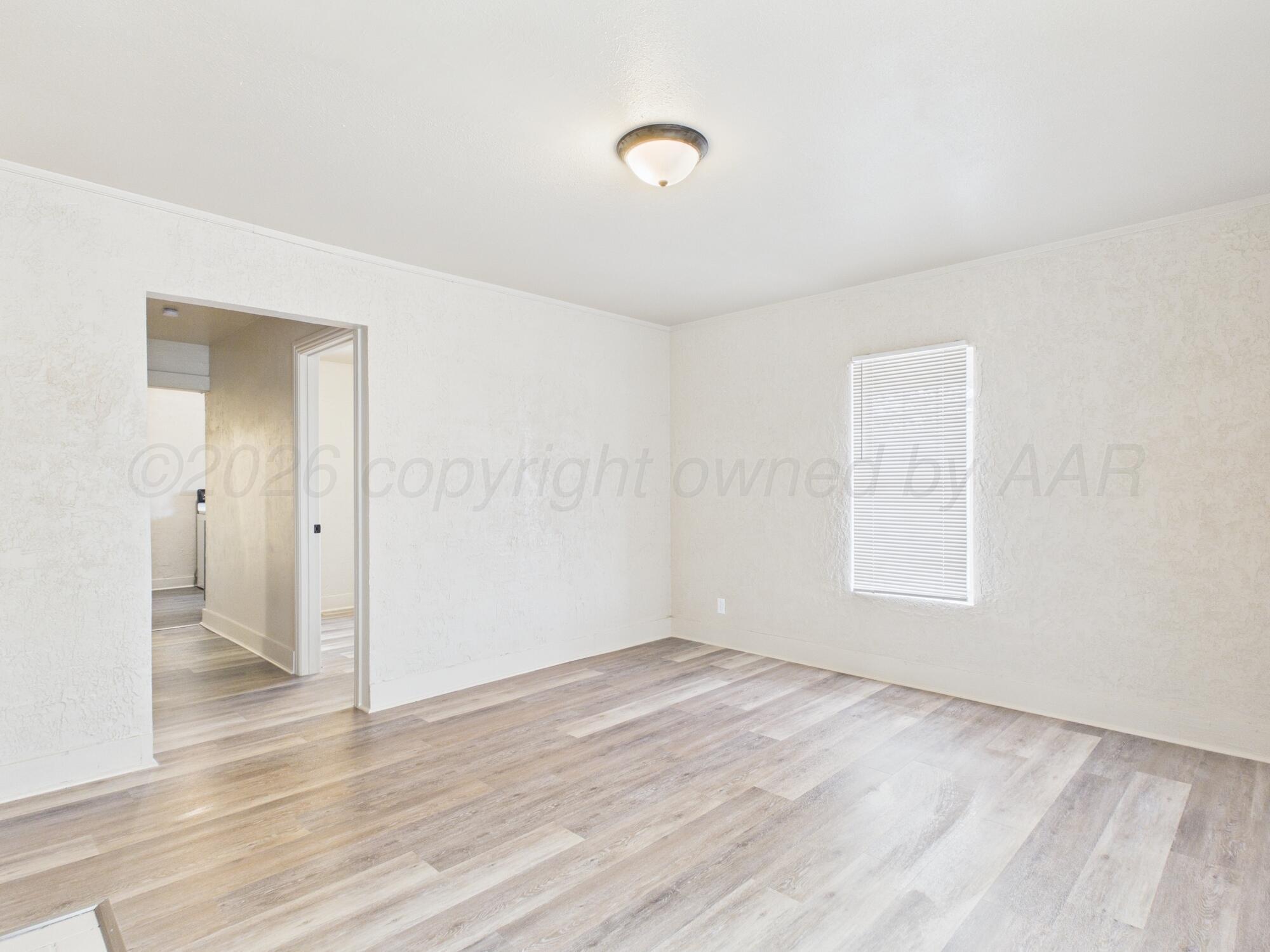 1111 Southwest 13th Avenue Amarillo, TX 79102 - Photo 13 of 20 an empty room with wooden floor and windows