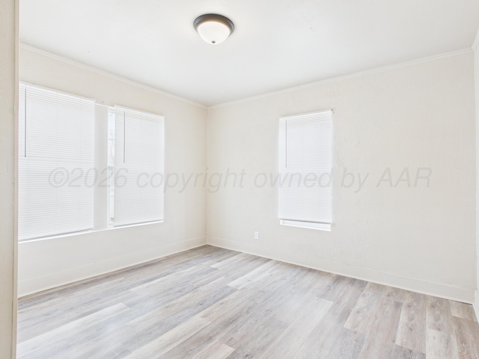 1111 Southwest 13th Avenue Amarillo, TX 79102 - Photo 16 of 20 an empty room with wooden floor and windows