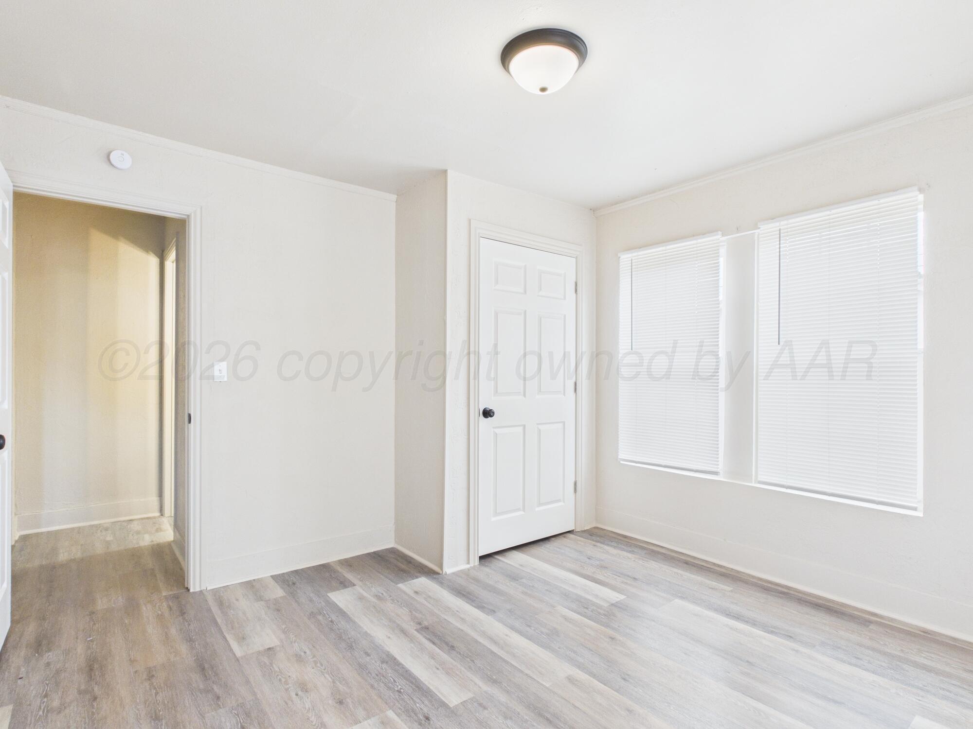 1111 Southwest 13th Avenue Amarillo, TX 79102 - Photo 17 of 20 an empty room with wooden floor and windows