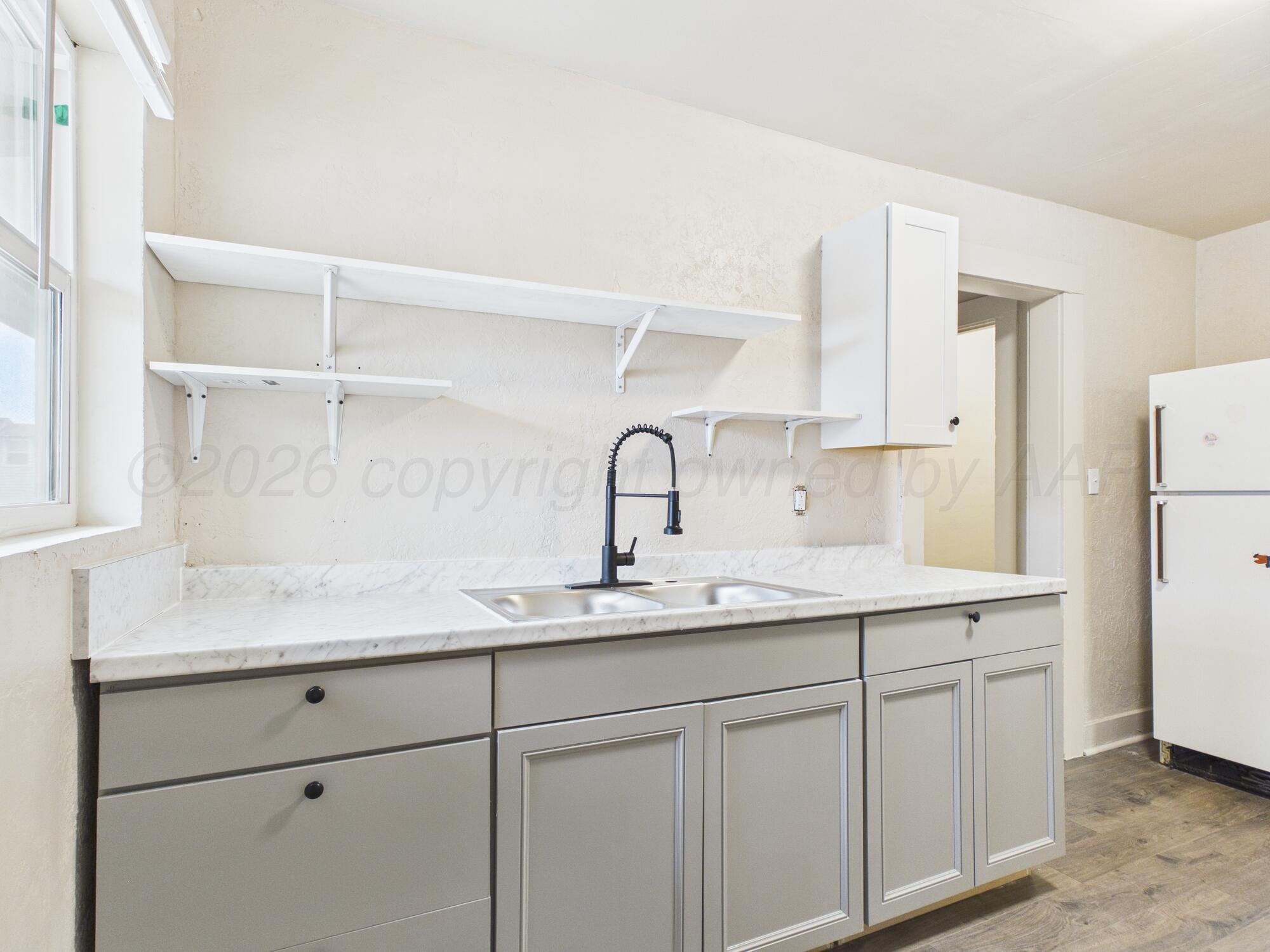 1111 Southwest 13th Avenue Amarillo, TX 79102 - Photo 3 of 20 a kitchen with a sink and a refrigerator