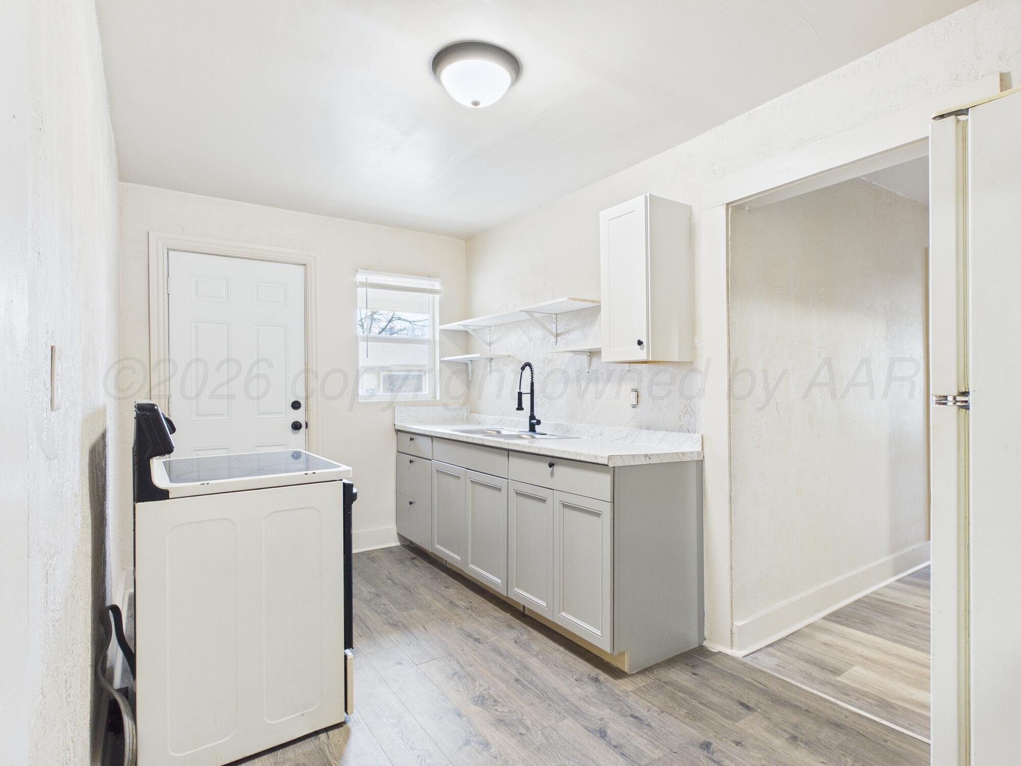 1111 Southwest 13th Avenue Amarillo, TX 79102 - Photo 4 of 20 a kitchen with sink a stove and refrigerator