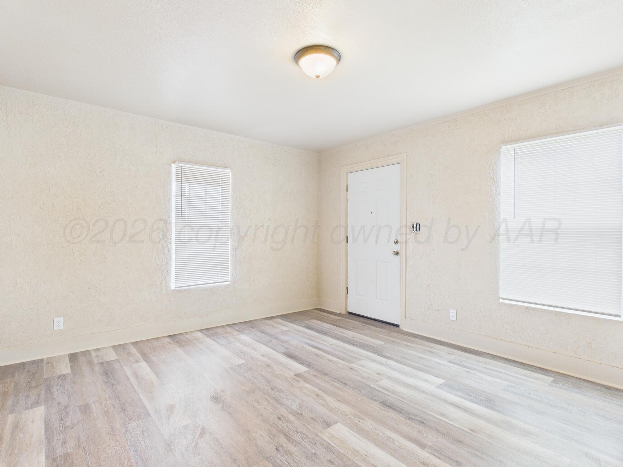 1111 Southwest 13th Avenue Amarillo, TX 79102 - Photo 10 of 20 an empty room with wooden floor and windows