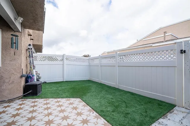a view of a backyard with chair and iron fence