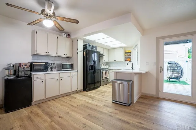 a kitchen with a refrigerator cabinets and wooden floor