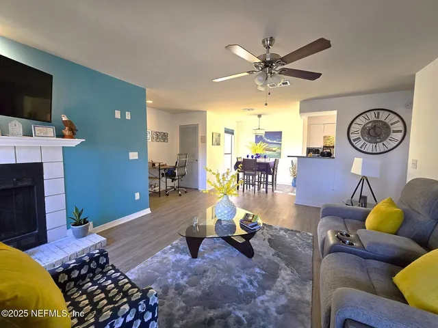 a living room with furniture a clock and a flat screen tv