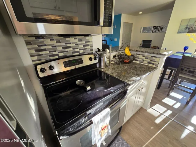 a stove top oven sitting inside of a kitchen