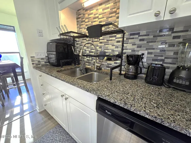 a kitchen with counter top a sink and a stove