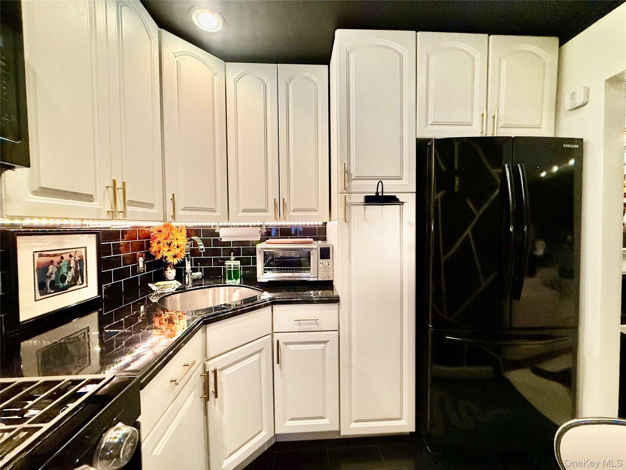 112-25 34th Avenue, Unit 2D Queens, NY 11368 - Photo 11 of 37 a kitchen with stainless steel appliances a refrigerator sink and cabinets