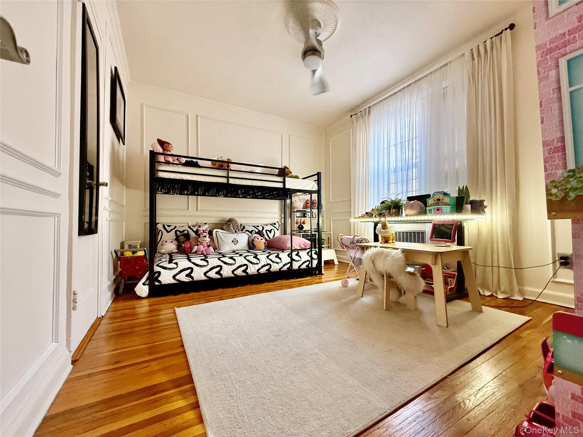 112-25 34th Avenue, Unit 2D Queens, NY 11368 - Photo 17 of 37 Bedroom featuring a decorative wall and wood-type flooring