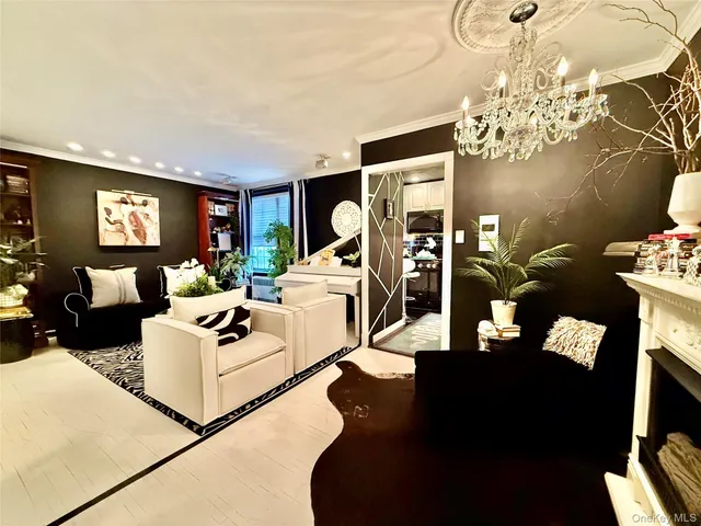 a living room with furniture a chandelier and a flat screen tv
