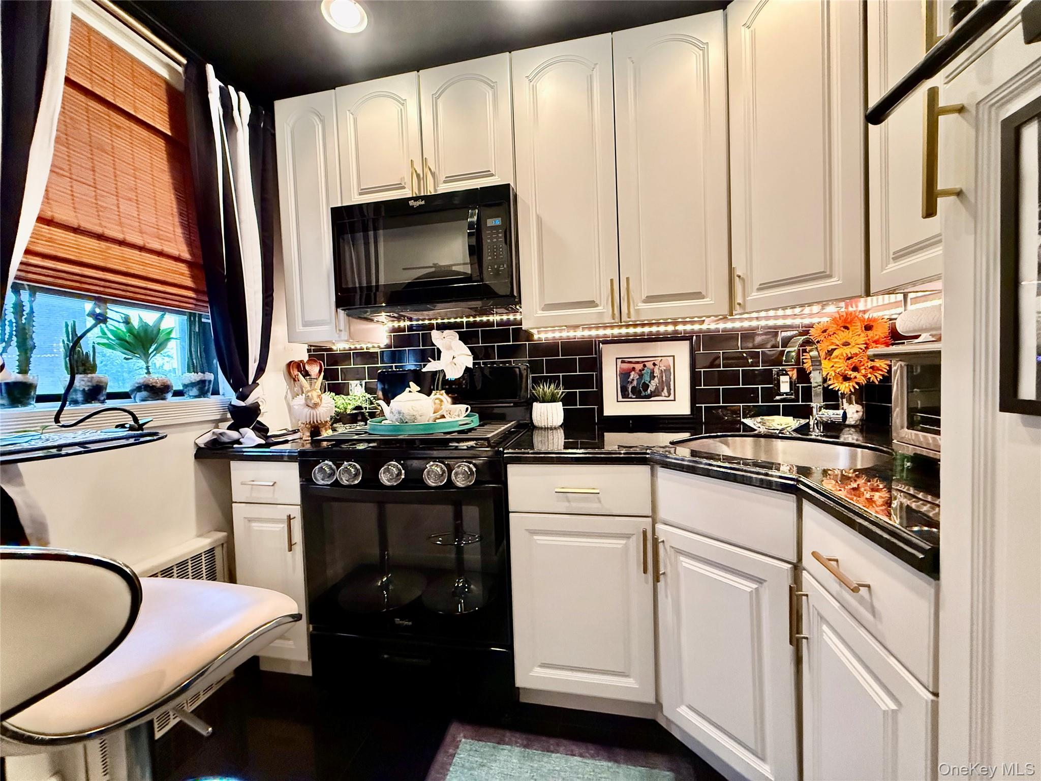 112-25 34th Avenue, Unit 2D Queens, NY 11368 - Photo 9 of 37 a kitchen with stainless steel appliances white cabinets and a stove top oven