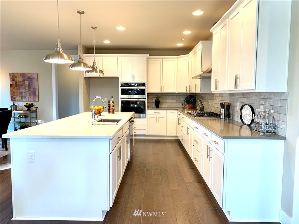 21632 2nd Court Southeast Bothell, WA 98021 - Photo 3 of 21 a kitchen with kitchen island granite countertop a sink a counter top space appliances and cabinets