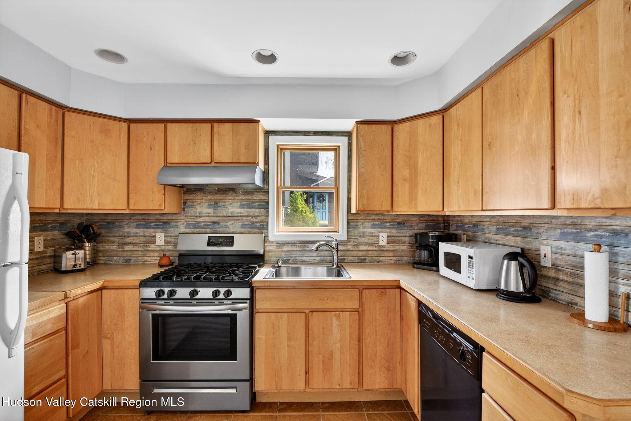 205 Esopus Creek Road Saugerties, NY 12477 - Photo 16 of 56 a kitchen with a sink a stove cabinets and a window