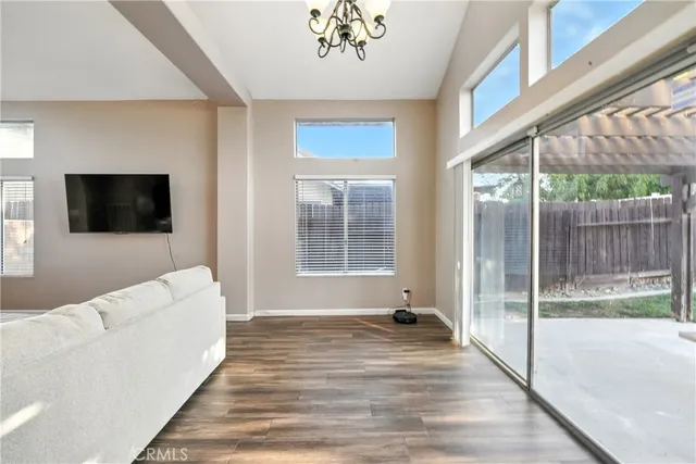 a living room with furniture tv and a floor to ceiling window
