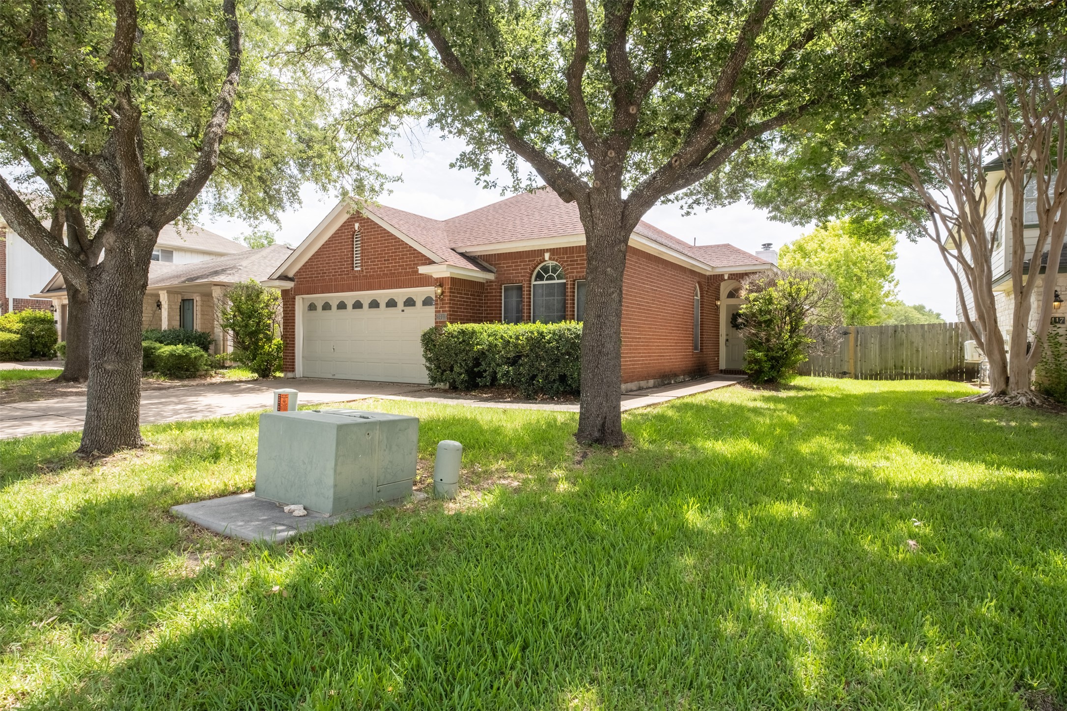 3413 Ruby Red Drive Austin, TX 78728 - Photo 1 of 1 A well-maintained red brick home sits under mature shade trees on a verdant lawn.