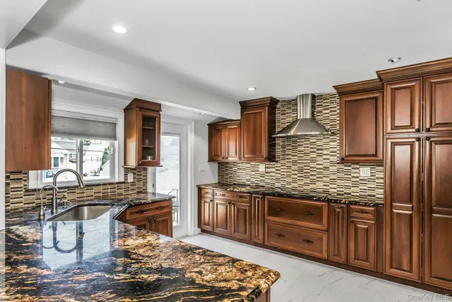 a kitchen with stainless steel appliances granite countertop a stove sink and cabinets