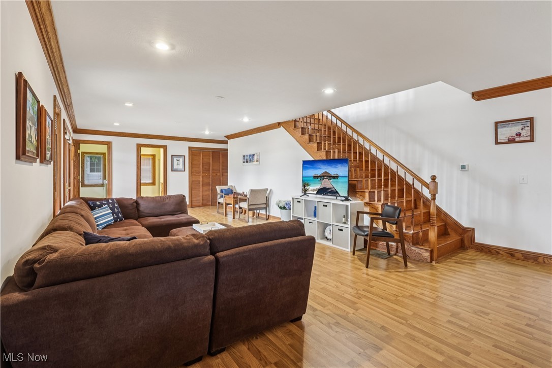 337 Cedar Point Road Sandusky, OH 44870 - Photo 17 of 50 Living room with crown molding, light wood-style flooring, stairway, and recessed lighting