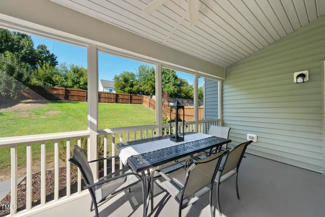 a view of a patio with couches table and chairs with wooden fence