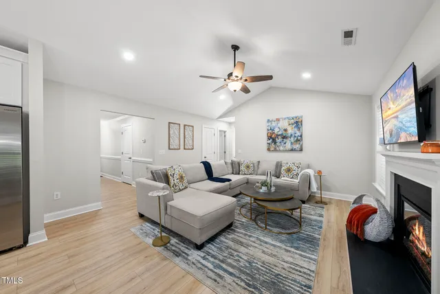 a living room with furniture a fireplace and a flat screen tv