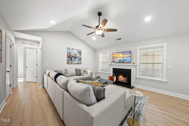 a living room with furniture a fireplace and a flat screen tv